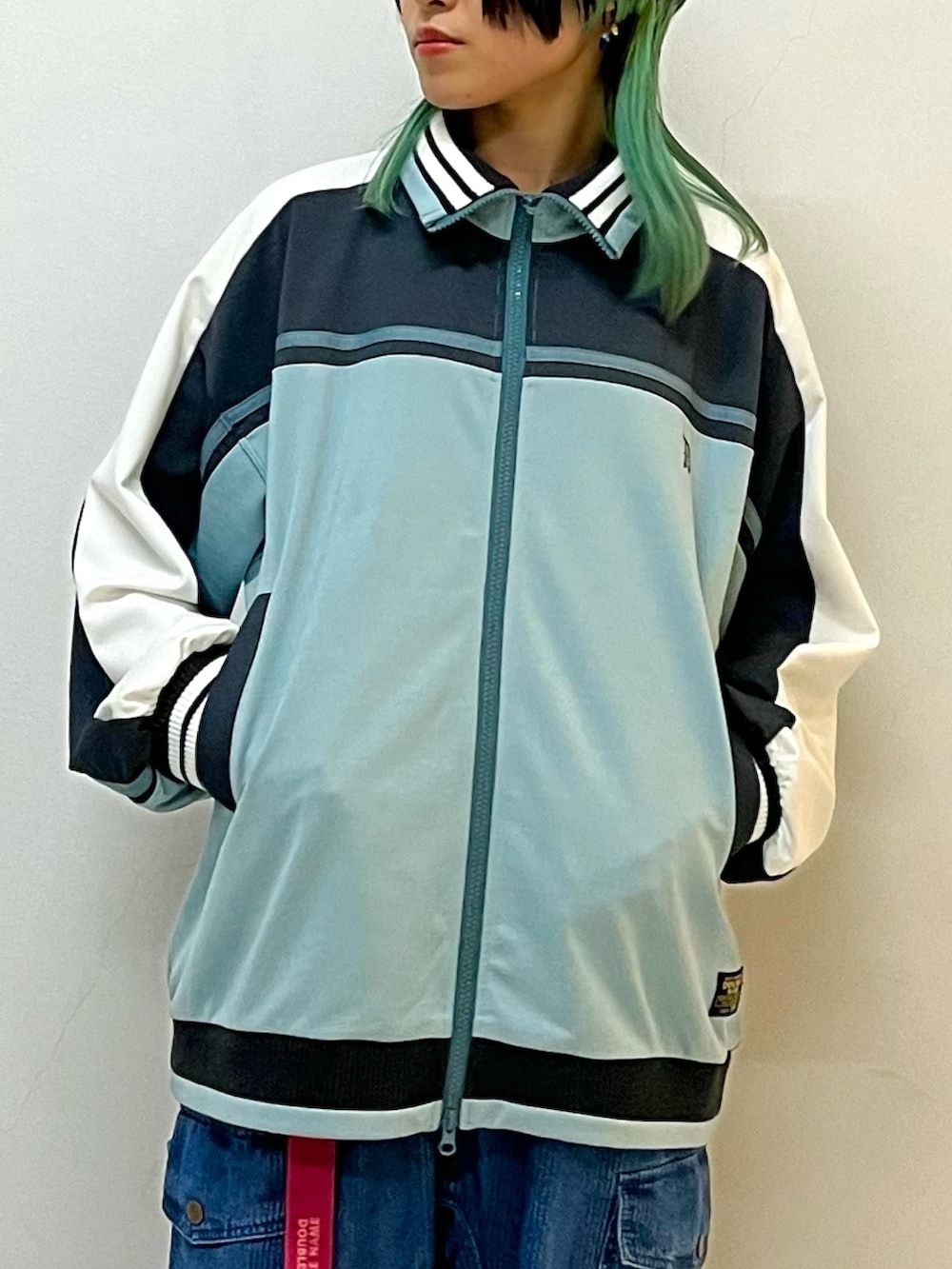 ブルー系のジャージ、ブルー系のデニムパンツ、ピンク系のベルトを着用したレディースの春コーディネートの4枚目の写真