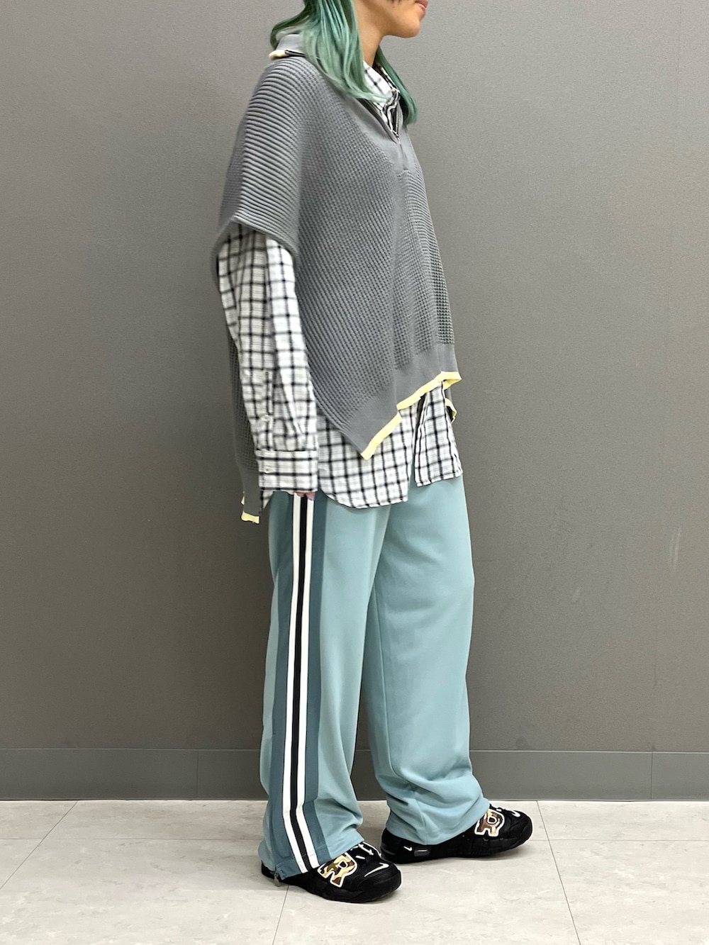 グレー系のニット/セーター、ホワイト系のシャツ/ブラウス、ブルー系のその他パンツを着用したレディースの春コーディネートの2枚目の写真