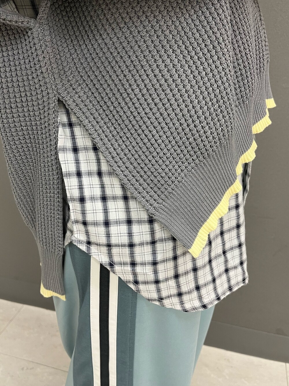 グレー系のニット/セーター、ホワイト系のシャツ/ブラウス、ブルー系のその他パンツを着用したレディースの春コーディネートの6枚目の写真