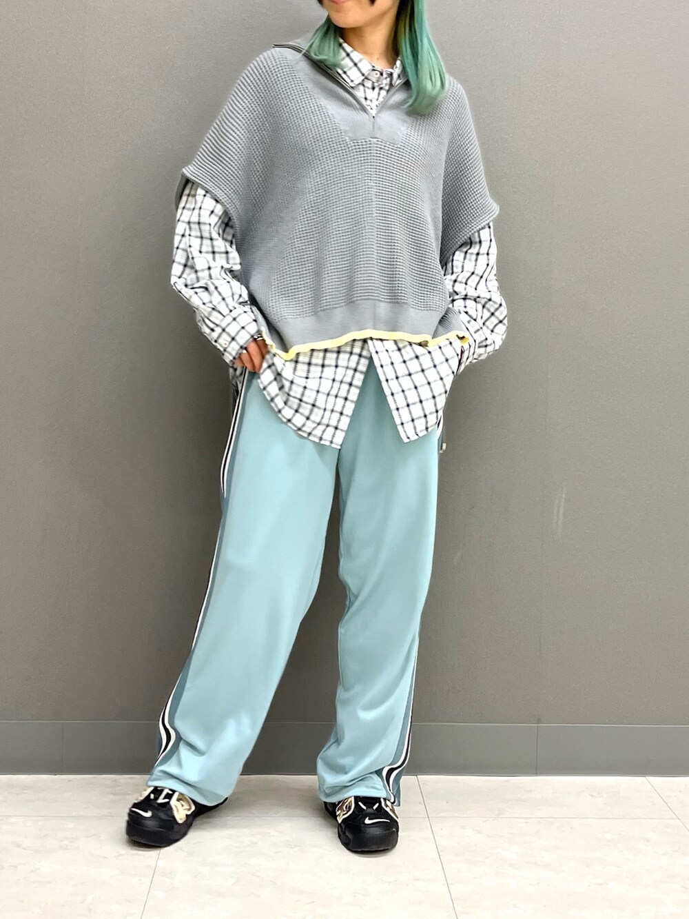 グレー系のニット/セーター、ホワイト系のシャツ/ブラウス、ブルー系のその他パンツを着用したレディースの春コーディネートの3枚目の写真