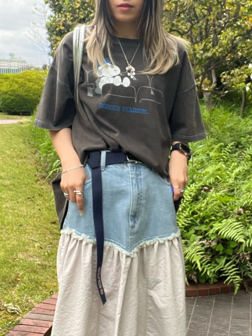 ホワイト系のスカート、ブラック系のTシャツ/カットソー、シルバー系のハンドバッグを着用したレディースの夏コーディネートの3枚目の写真