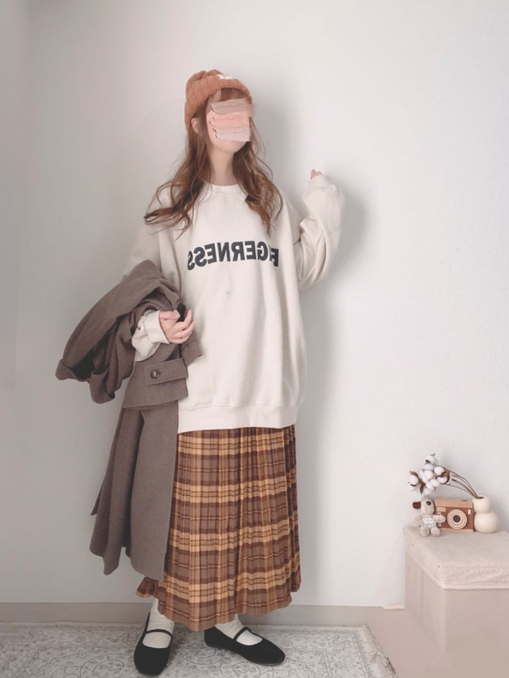 ブラウン系のチェスターコート、ホワイト系のスウェット、ブラウン系のスカートを着用したレディースの冬コーディネートの4枚目の写真