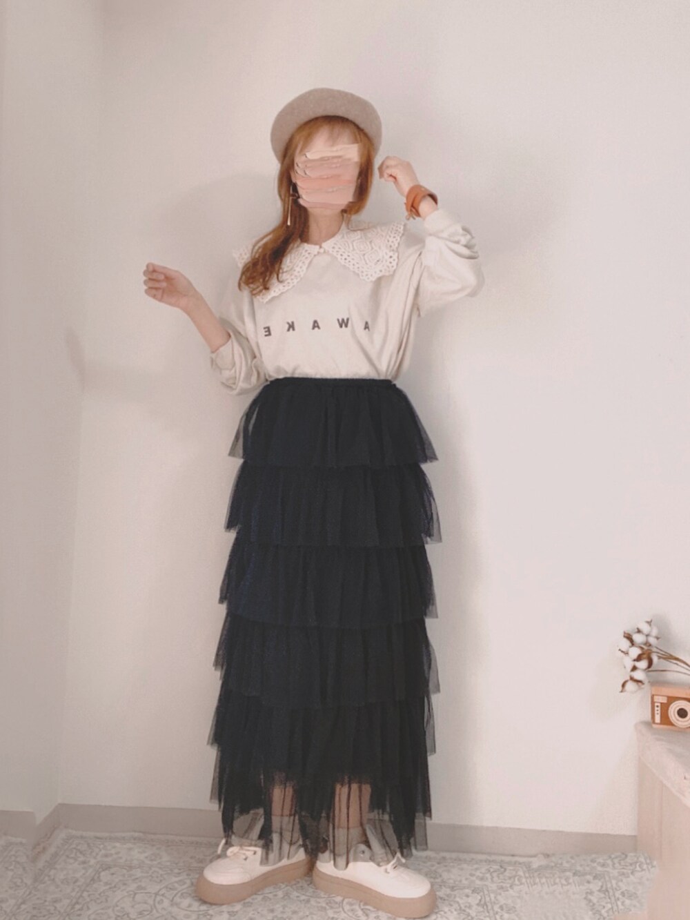 ブラック系のスカート、ホワイト系のTシャツ/カットソー、ベージュ系のスニーカーを着用したレディースの春コーディネートの2枚目の写真
