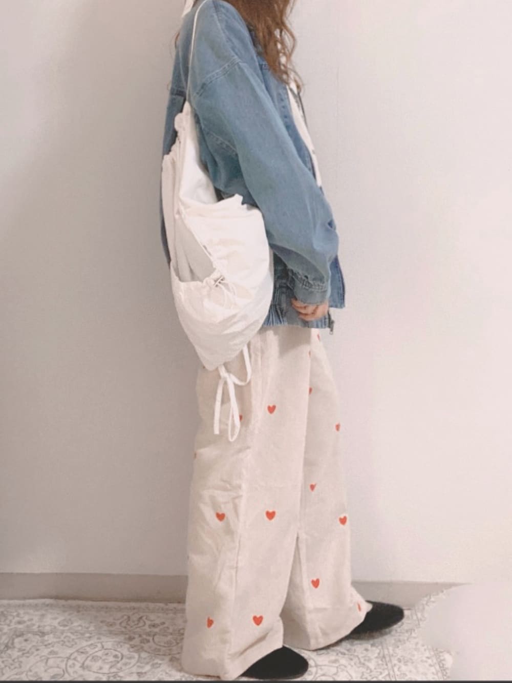 ブルー系のブルゾン、ホワイト系のスウェット、ホワイト系のパンツを着用したレディースの冬コーディネートの3枚目の写真