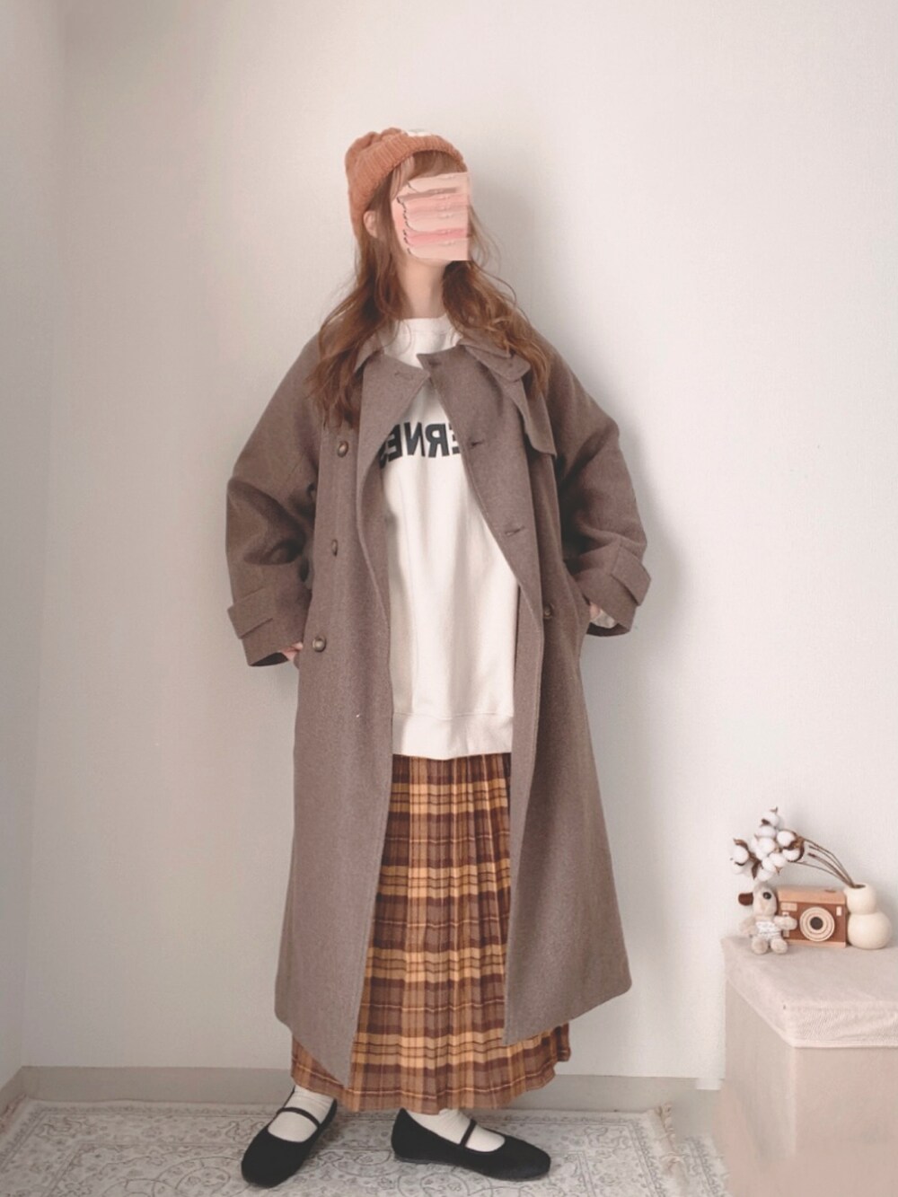 ブラウン系のチェスターコート、ホワイト系のスウェット、ブラウン系のスカートを着用したレディースの冬コーディネートの2枚目の写真