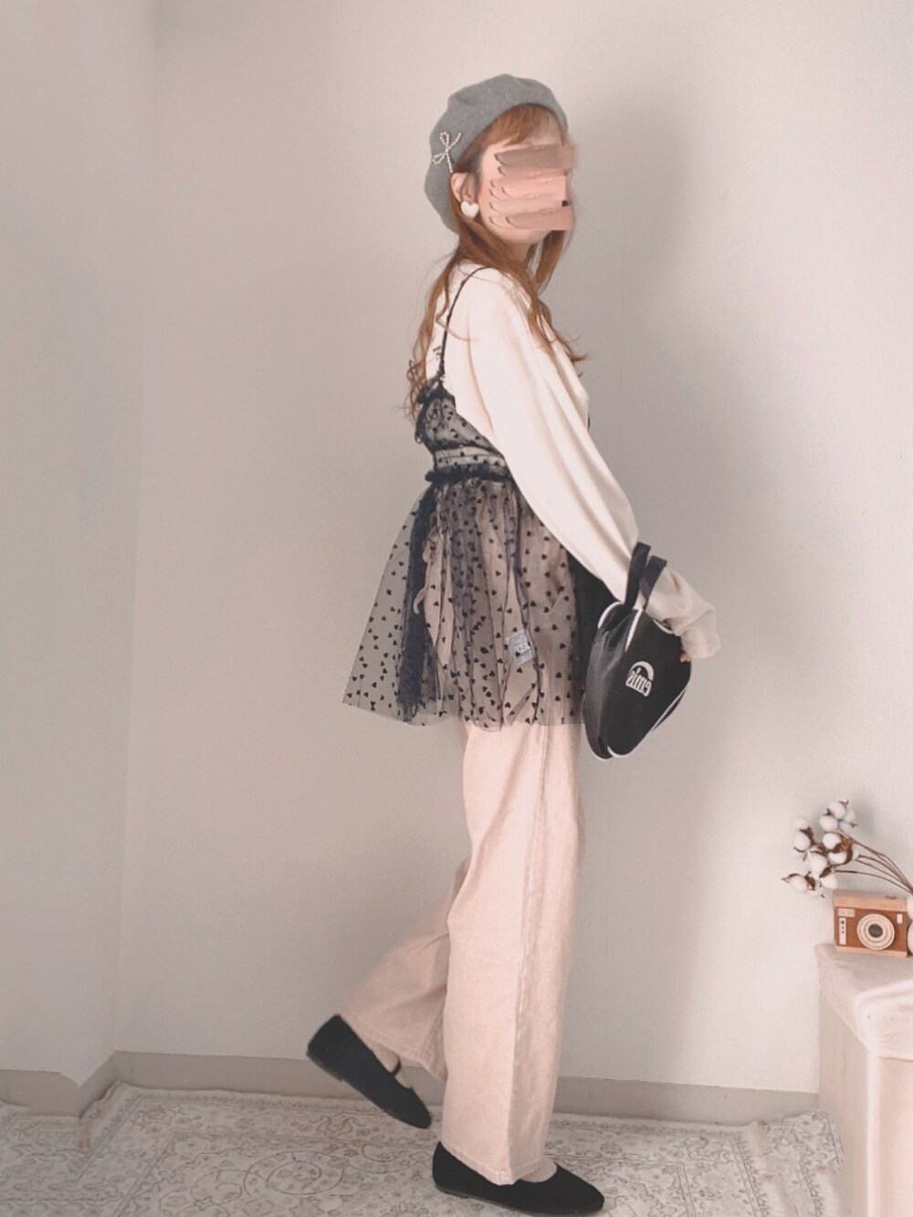 ピンク系のデニムパンツ、ブラック系のキャミソール、ブラック系のハンドバッグを着用したレディースの冬コーディネートの2枚目の写真