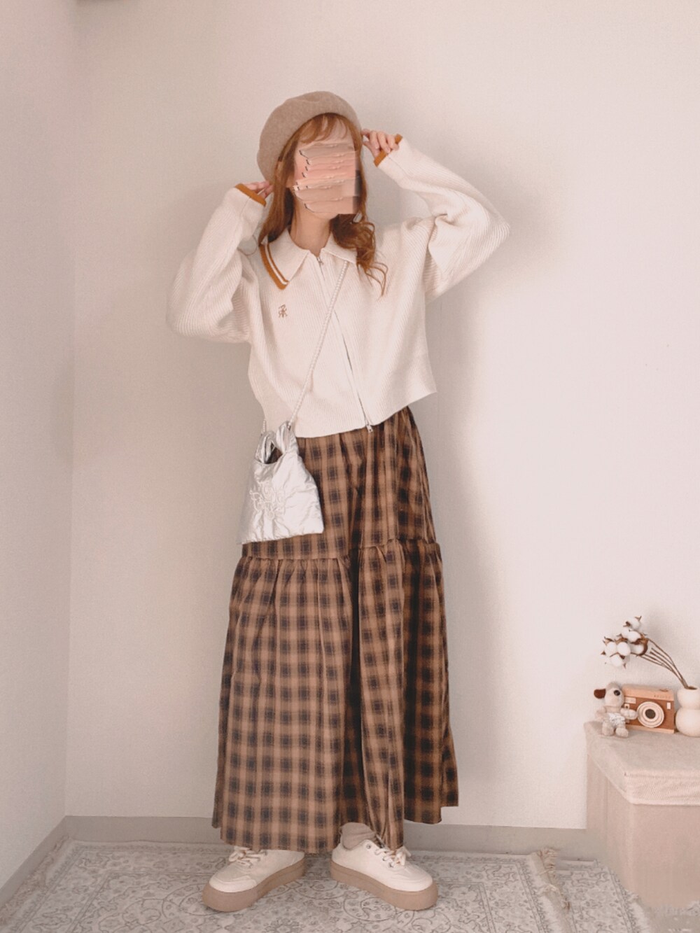 ホワイト系のニット/セーター、ベージュ系のワンピース、ベージュ系のスニーカーを着用したレディースの冬コーディネートの2枚目の写真