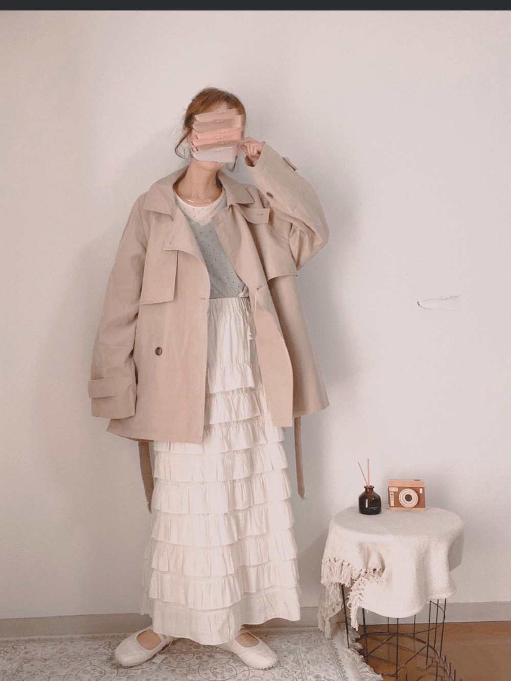 ベージュ系のトレンチコート、ホワイト系のTシャツ/カットソー、ベージュ系のスカートを着用したレディースの春コーディネートの2枚目の写真