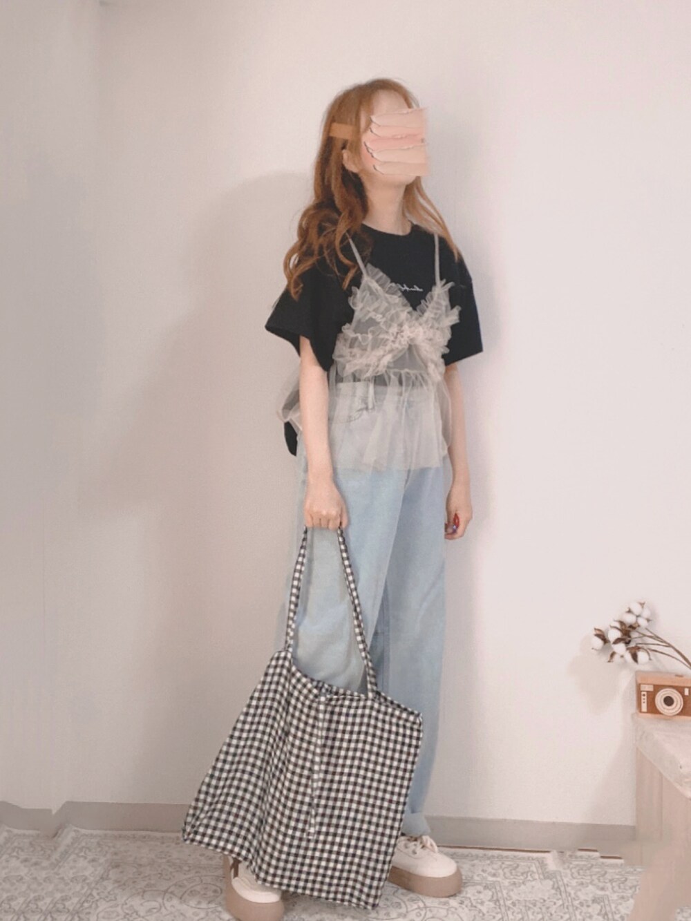 ブラック系のTシャツ/カットソー、ベージュ系のキャミソール、ブルー系のデニムパンツを着用したレディースの夏コーディネートの3枚目の写真