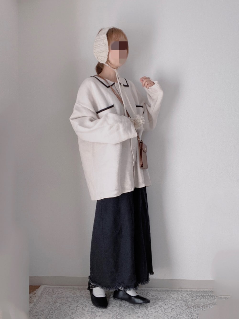 ホワイト系のカーディガン/ボレロ、ブラック系のジャンパースカート、ブラック系のバレエシューズを着用したレディースの冬コーディネートの2枚目の写真