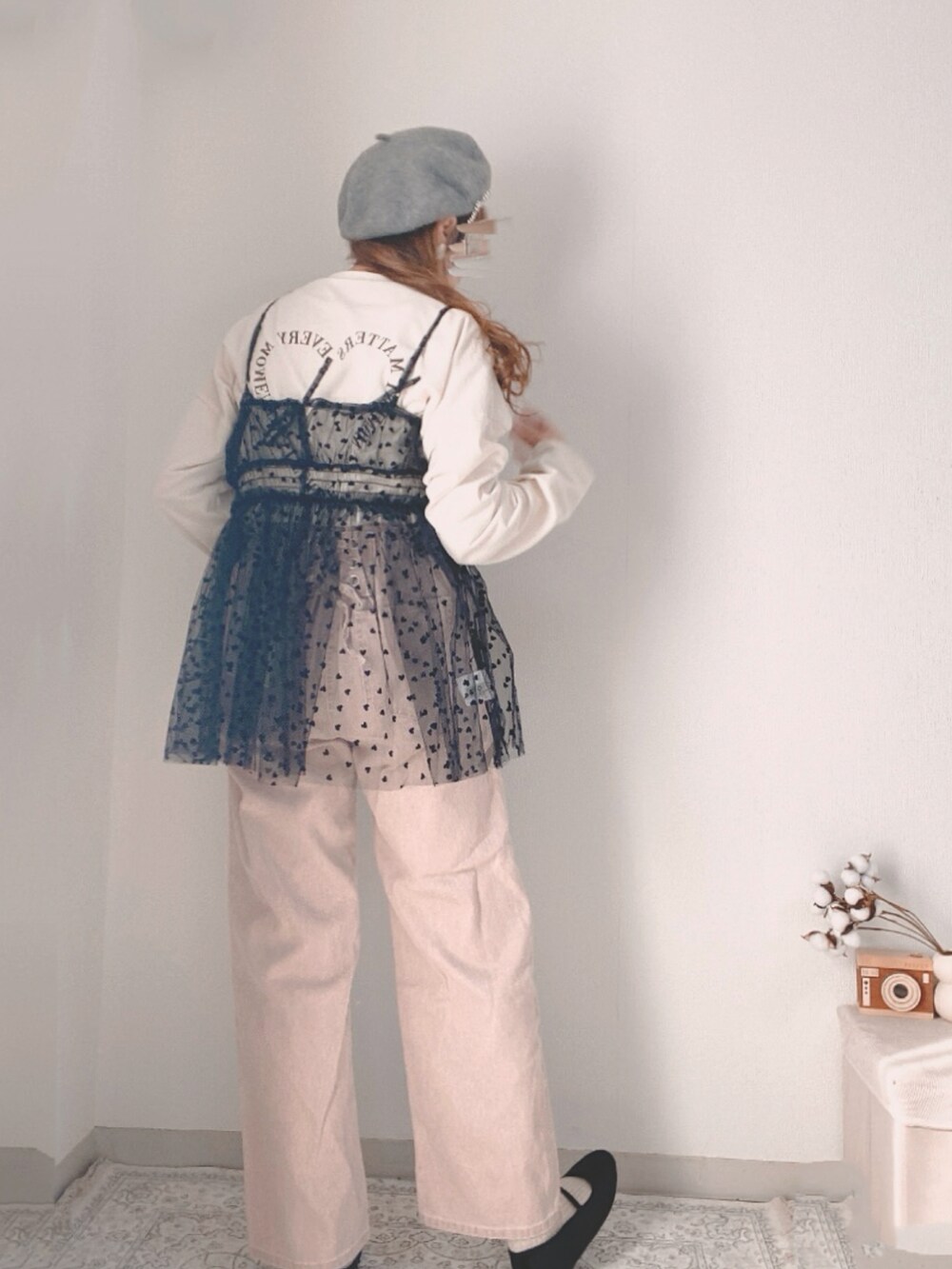 ピンク系のデニムパンツ、ブラック系のキャミソール、ブラック系のハンドバッグを着用したレディースの冬コーディネートの3枚目の写真