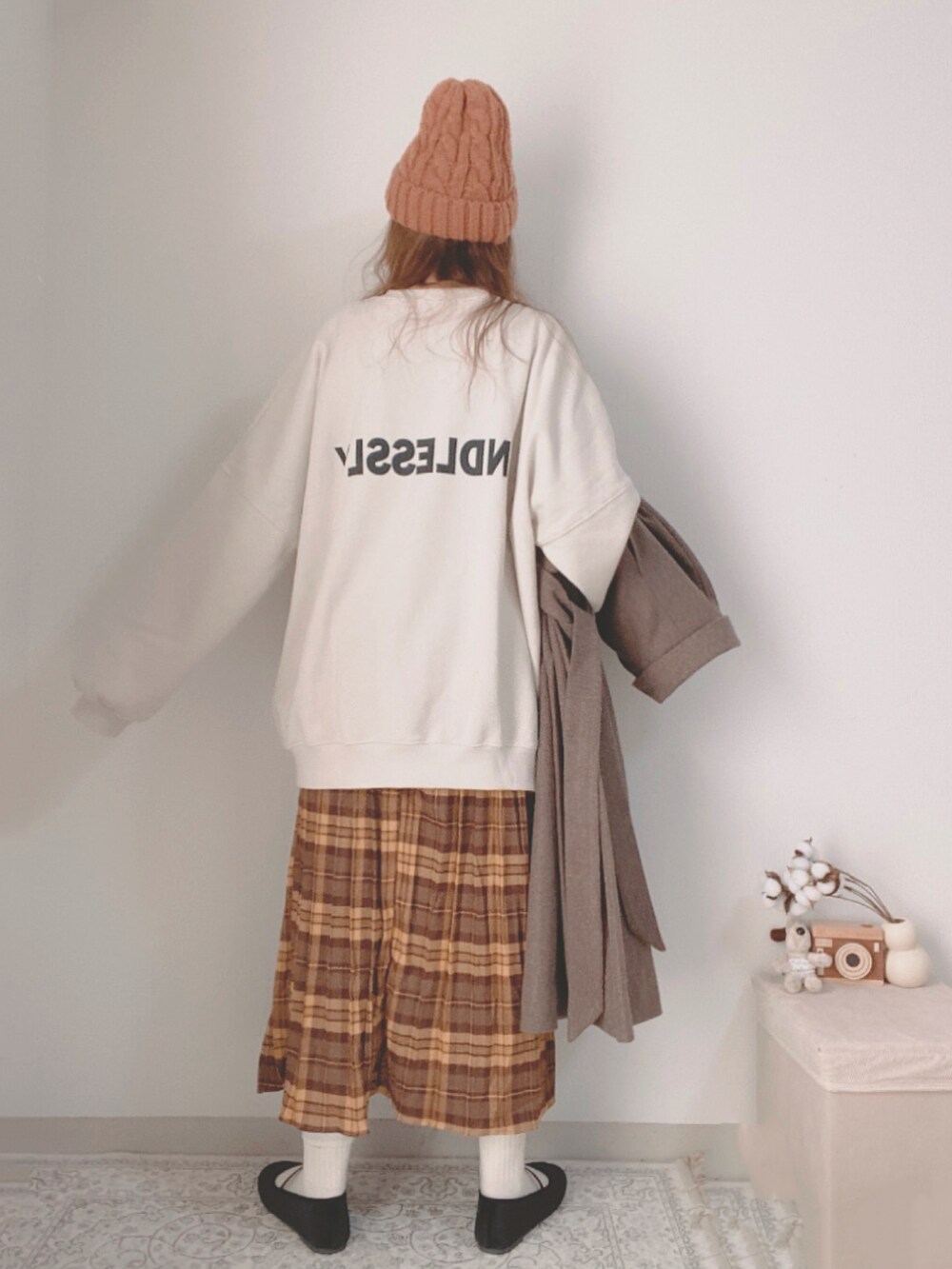 ブラウン系のチェスターコート、ホワイト系のスウェット、ブラウン系のスカートを着用したレディースの冬コーディネートの5枚目の写真