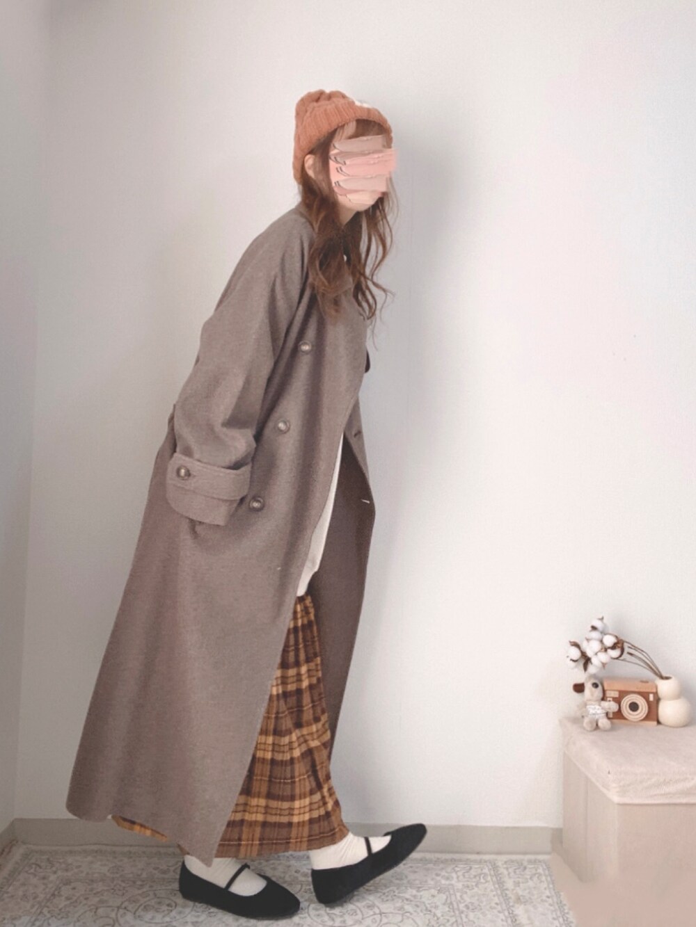 ブラウン系のチェスターコート、ホワイト系のスウェット、ブラウン系のスカートを着用したレディースの冬コーディネートの3枚目の写真