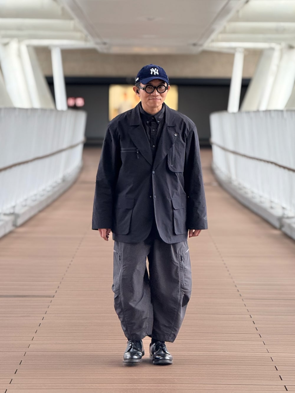 ブラック系のテーラードジャケット、グレー系のその他パンツ、ブラック系のドレスシューズを着用したメンズの春コーディネートの5枚目の写真