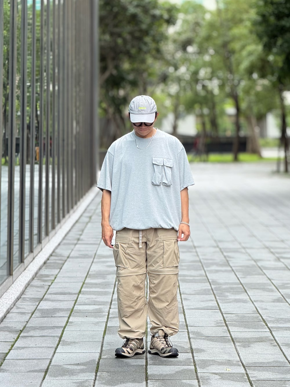 グレー系のTシャツ/カットソー、ベージュ系のチノパンツ、グリーン系のスニーカーを着用したメンズの夏コーディネートの2枚目の写真