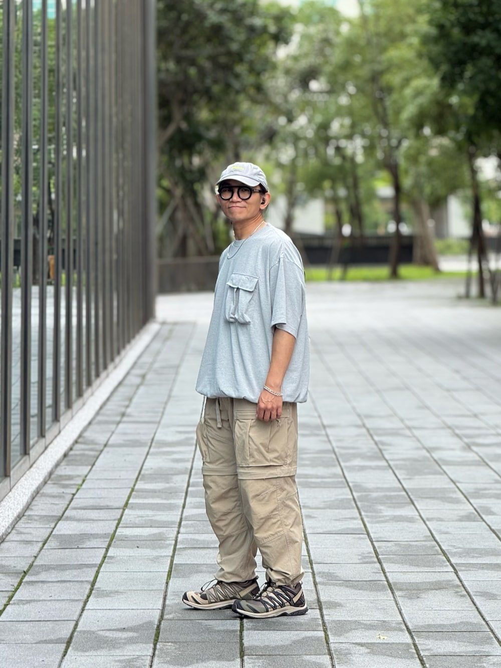 グレー系のTシャツ/カットソー、ベージュ系のチノパンツ、グリーン系のスニーカーを着用したメンズの夏コーディネートの3枚目の写真