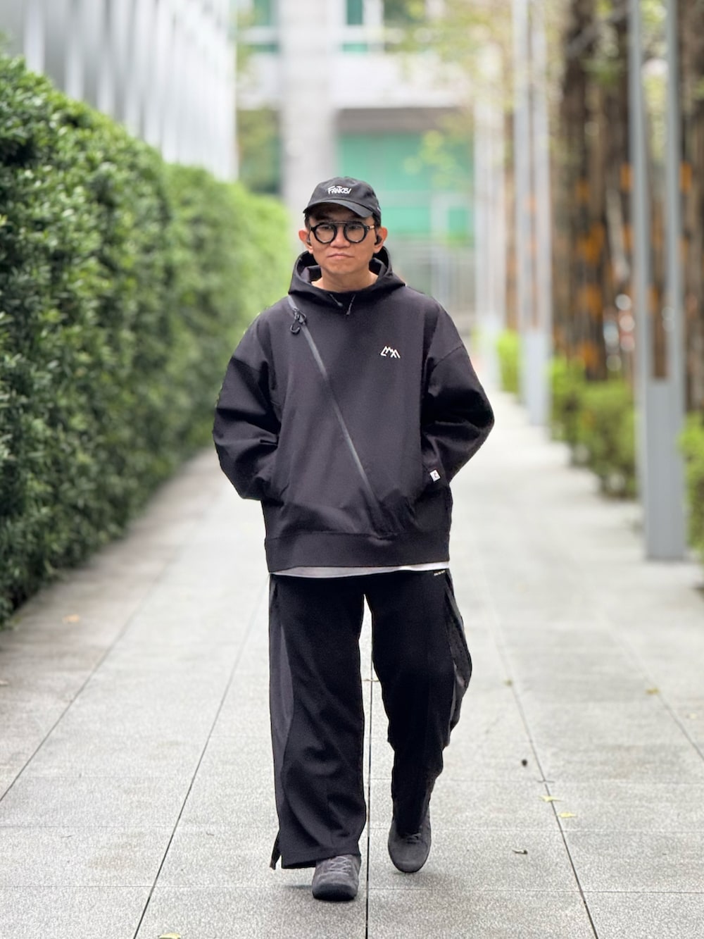 ブラック系のスウェット、ブラック系のチノパンツ、グレー系のスニーカーを着用したメンズの冬コーディネートの2枚目の写真