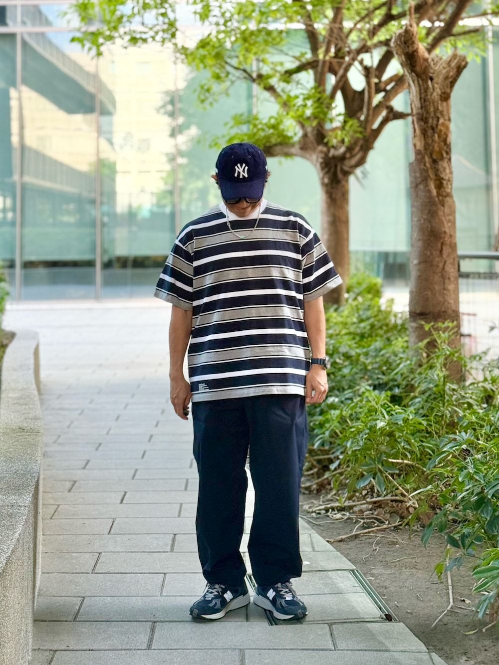 グレー系のTシャツ/カットソー、ブルー系のチノパンツ、ブルー系のスニーカーを着用したメンズの秋コーディネートの5枚目の写真