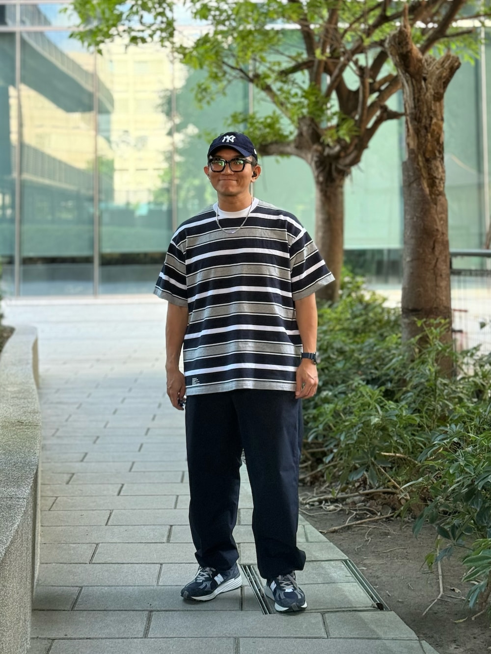 グレー系のTシャツ/カットソー、ブルー系のチノパンツ、ブルー系のスニーカーを着用したメンズの秋コーディネートの4枚目の写真