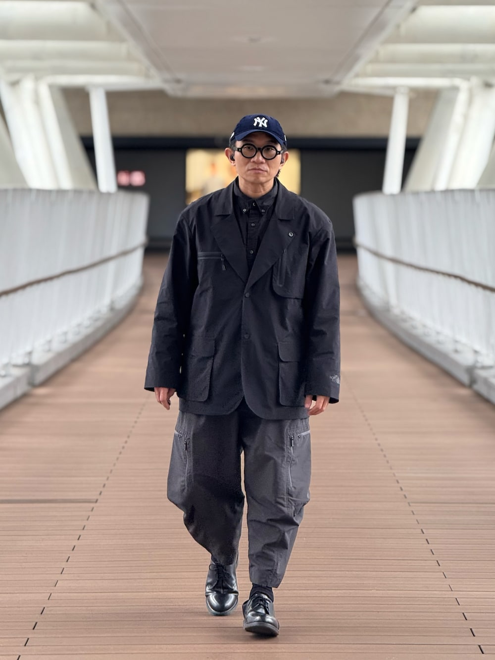 ブラック系のテーラードジャケット、グレー系のその他パンツ、ブラック系のドレスシューズを着用したメンズの春コーディネートの2枚目の写真