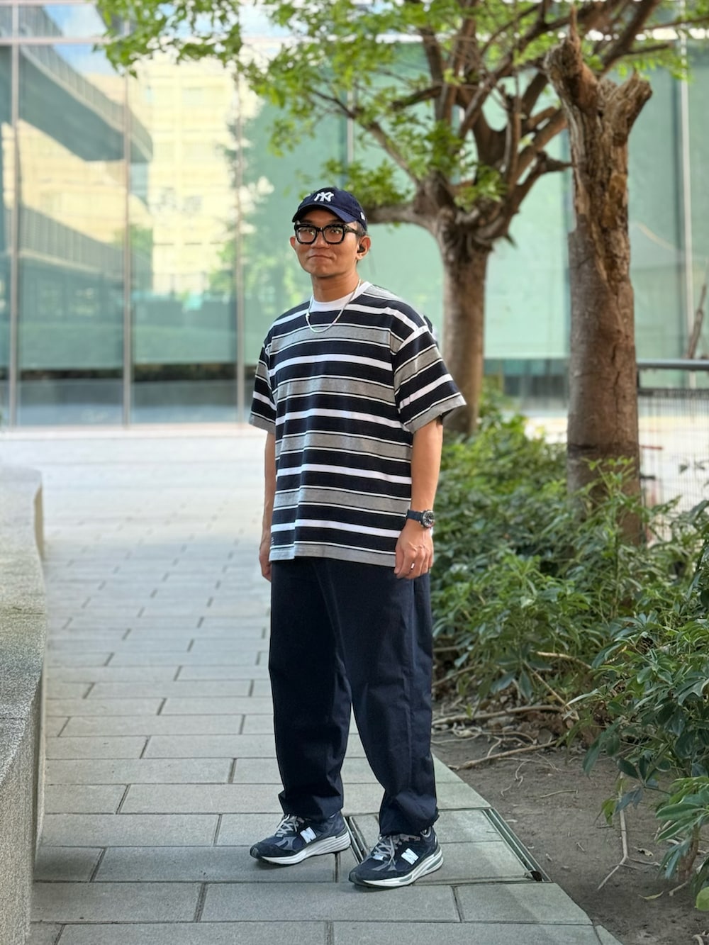 グレー系のTシャツ/カットソー、ブルー系のチノパンツ、ブルー系のスニーカーを着用したメンズの秋コーディネートの3枚目の写真