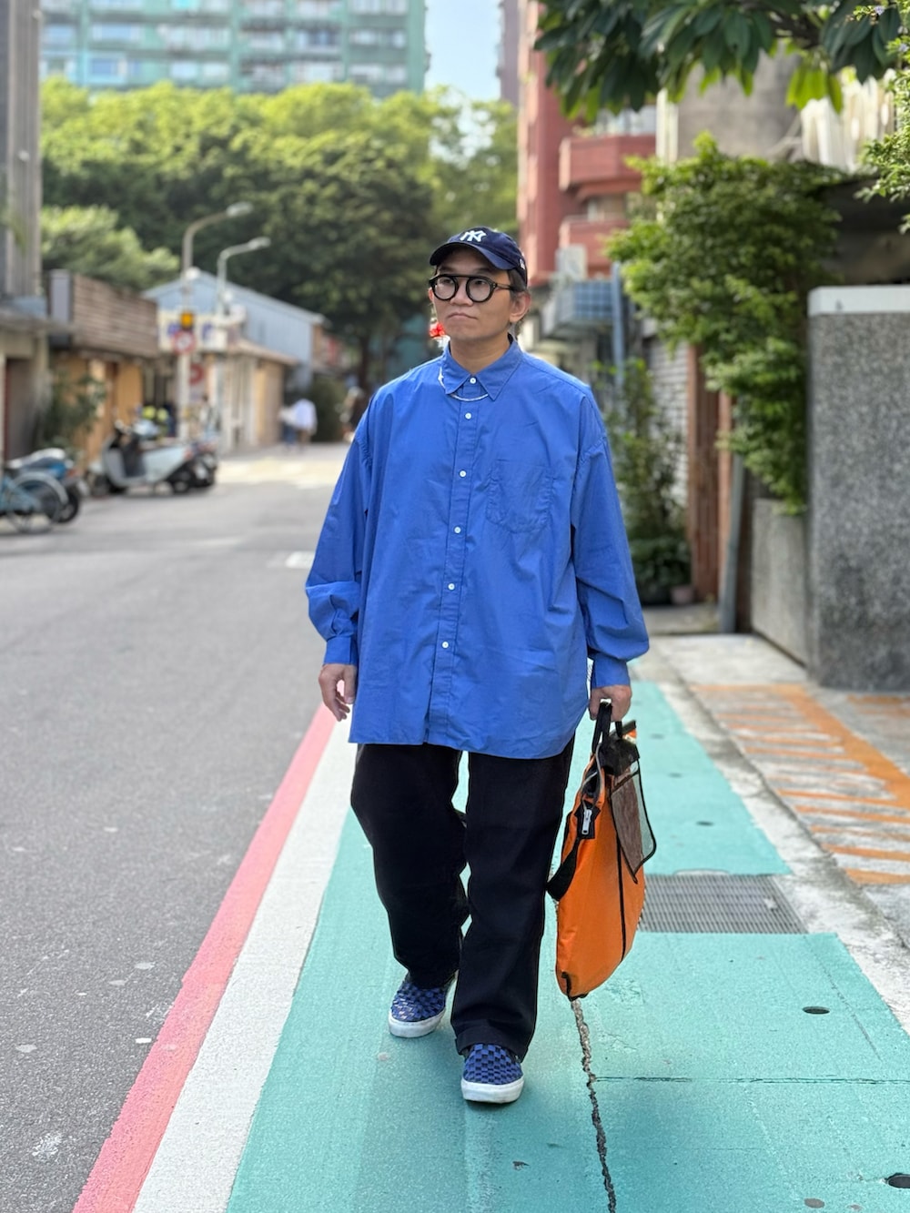 ブルー系のシャツ/ブラウス、ブルー系のチノパンツ、ブルー系のスニーカーを着用したメンズの秋コーディネートの4枚目の写真