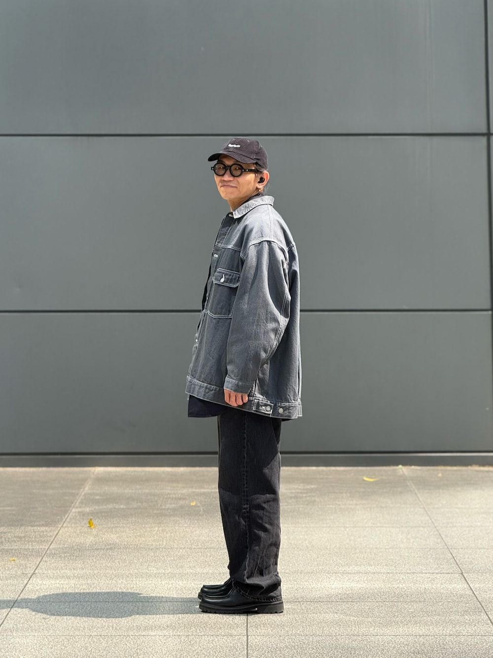 グレー系のデニムジャケット、グレー系のチノパンツ、ブラック系のその他シューズを着用したメンズの春コーディネートの4枚目の写真