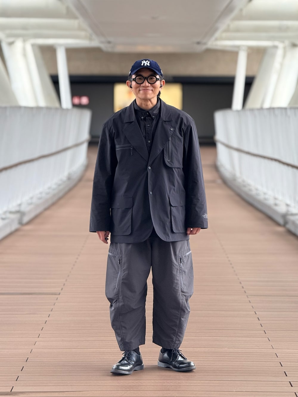 ブラック系のテーラードジャケット、グレー系のその他パンツ、ブラック系のドレスシューズを着用したメンズの春コーディネートの4枚目の写真