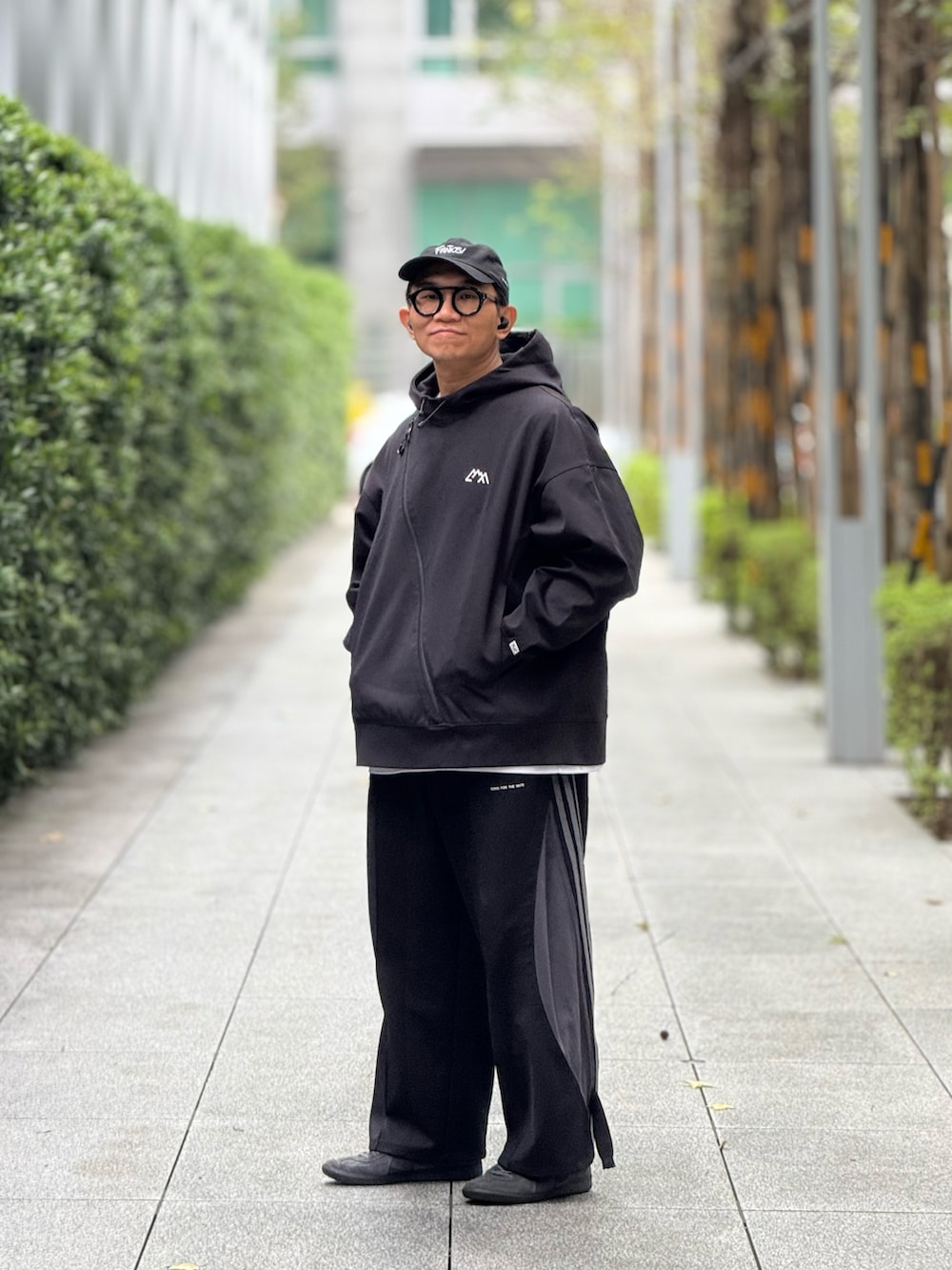 ブラック系のスウェット、ブラック系のチノパンツ、グレー系のスニーカーを着用したメンズの冬コーディネートの5枚目の写真