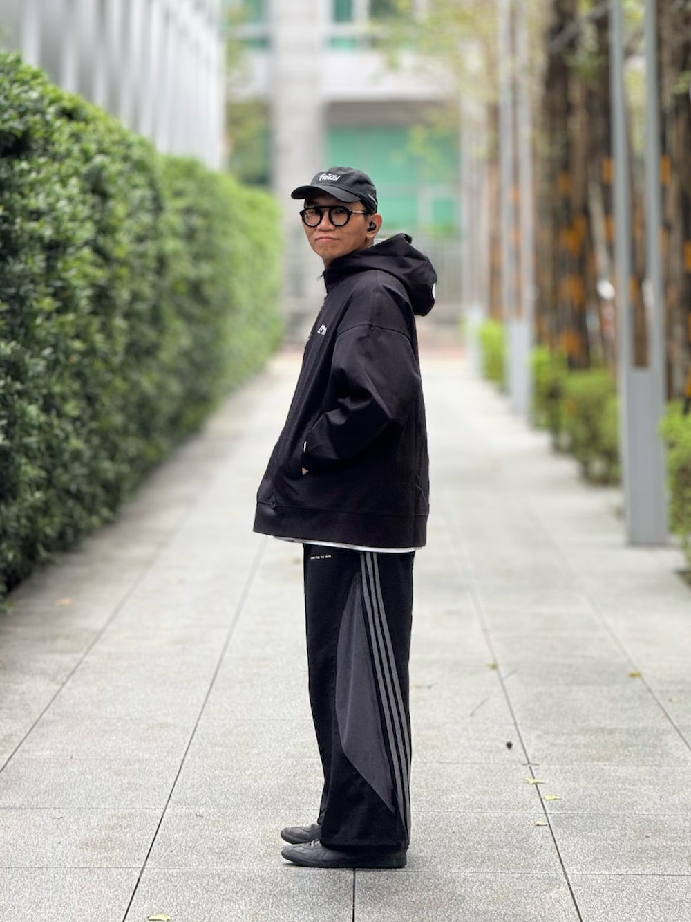 ブラック系のスウェット、ブラック系のチノパンツ、グレー系のスニーカーを着用したメンズの冬コーディネートの4枚目の写真