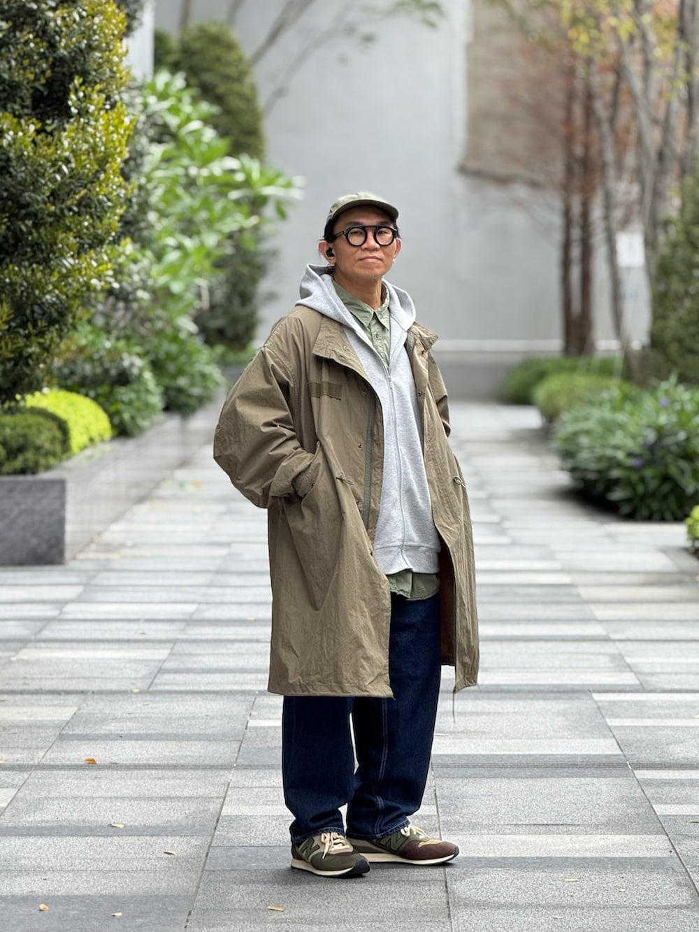 グレー系のスタジャン、グリーン系のミリタリージャケット、ブルー系のデニムパンツを着用したメンズの春コーディネートの5枚目の写真