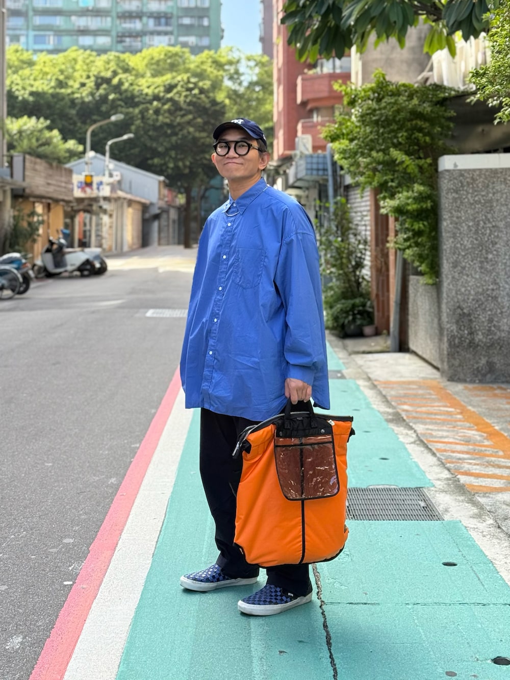 ブルー系のシャツ/ブラウス、ブルー系のチノパンツ、ブルー系のスニーカーを着用したメンズの秋コーディネートの3枚目の写真