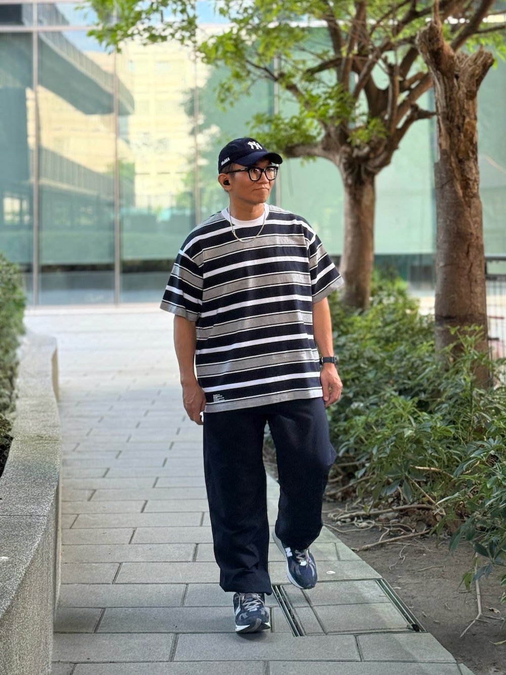 グレー系のTシャツ/カットソー、ブルー系のチノパンツ、ブルー系のスニーカーを着用したメンズの秋コーディネートの2枚目の写真