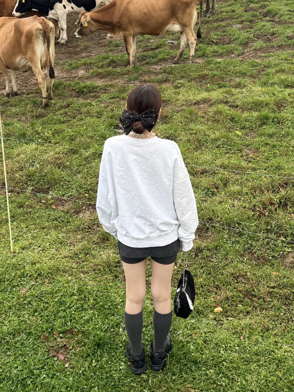 グレー系のスウェット、グレー系のその他パンツ、ブラック系のスニーカーを着用したレディースの秋コーディネートの2枚目の写真