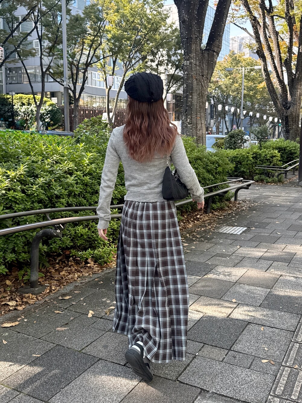 ブラウン系のスカートを着用したレディースの秋コーディネートの3枚目の写真