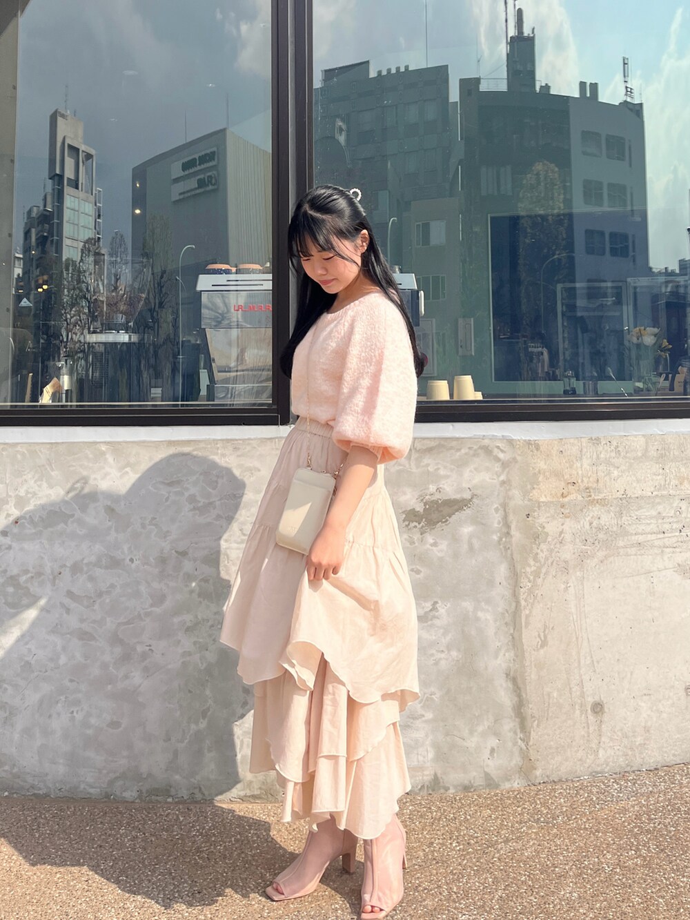 ピンク系のニット/セーター、ブラウン系のブーツ、ベージュ系のスカートを着用したレディースの春コーディネートの3枚目の写真