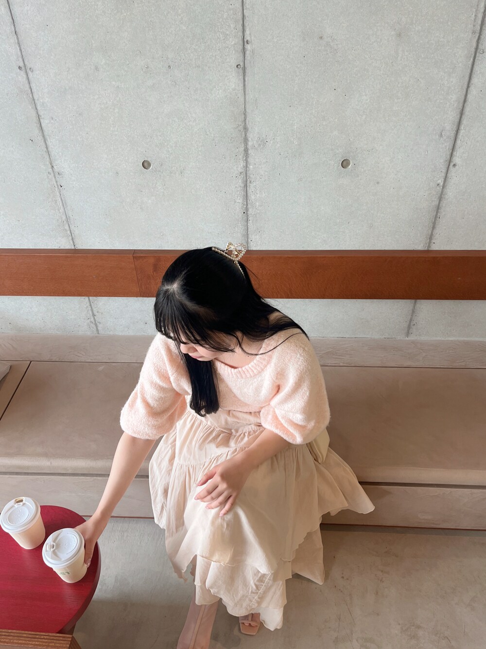 ピンク系のニット/セーター、ブラウン系のブーツ、ベージュ系のスカートを着用したレディースの春コーディネートの2枚目の写真