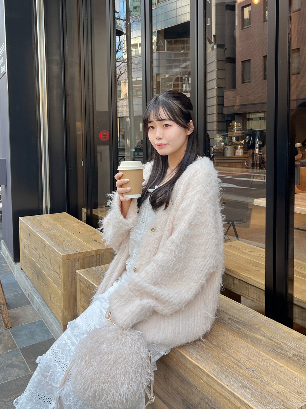 ピンク系のカーディガン/ボレロ、ホワイト系のショルダーバッグを着用したレディースの冬コーディネートの3枚目の写真