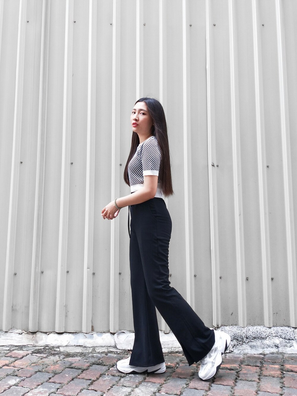 ホワイト系のスニーカーを着用したレディースの秋コーディネートの2枚目の写真