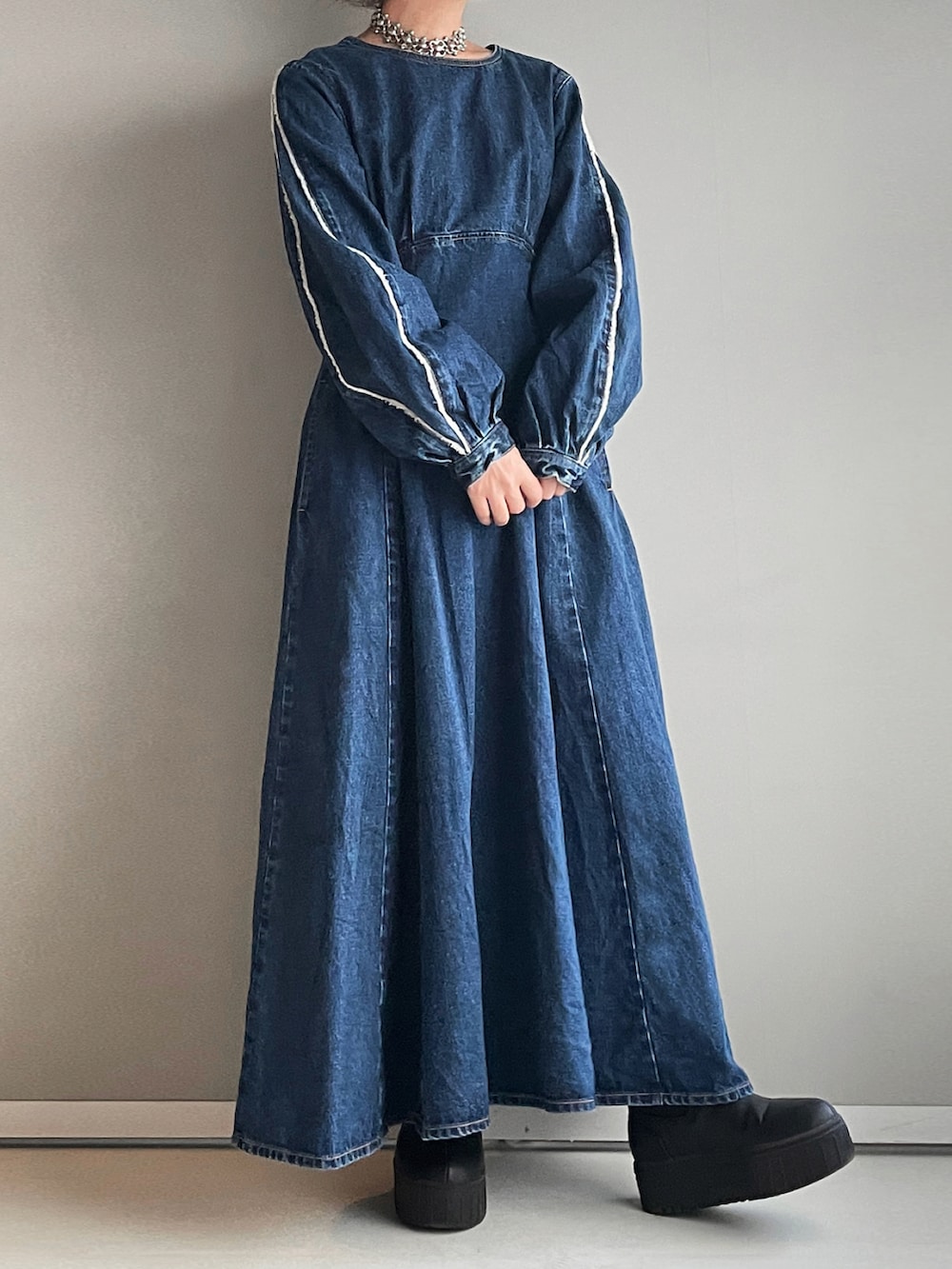 ブルー系のワンピース、ブラック系のブーツを着用したレディースの冬コーディネートの2枚目の写真