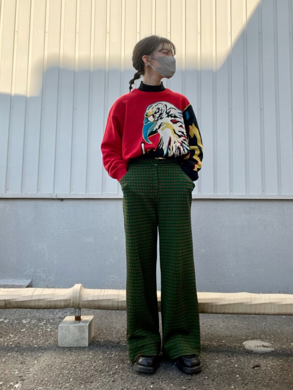 レッド系のニット/セーター、ブラック系のベスト、グリーン系のパンツを着用したレディースの冬コーディネートの2枚目の写真