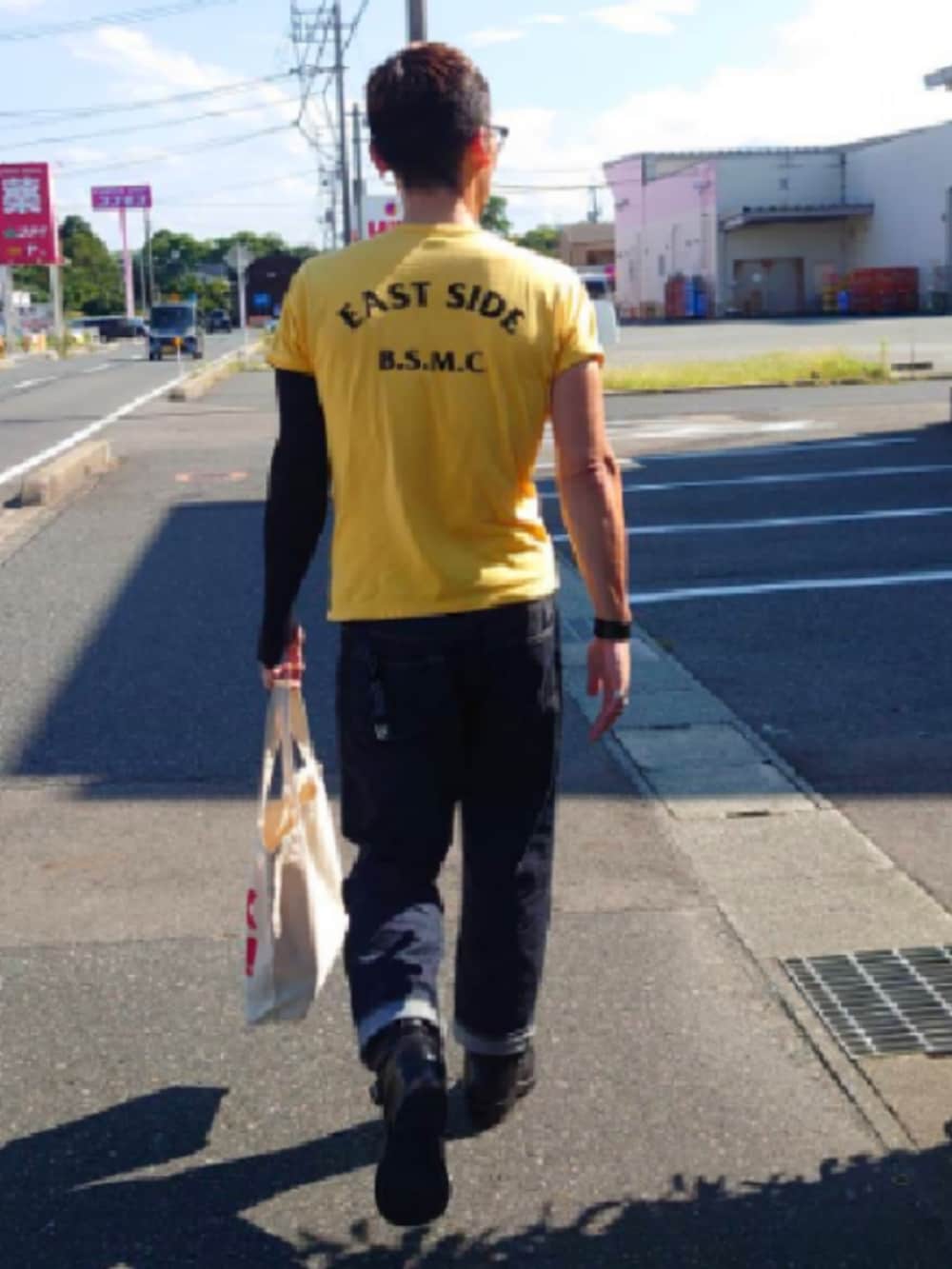 イエロー系のTシャツ/カットソー、ブルー系のデニムパンツ、ブラック系のブーツを着用したメンズの夏コーディネートの2枚目の写真