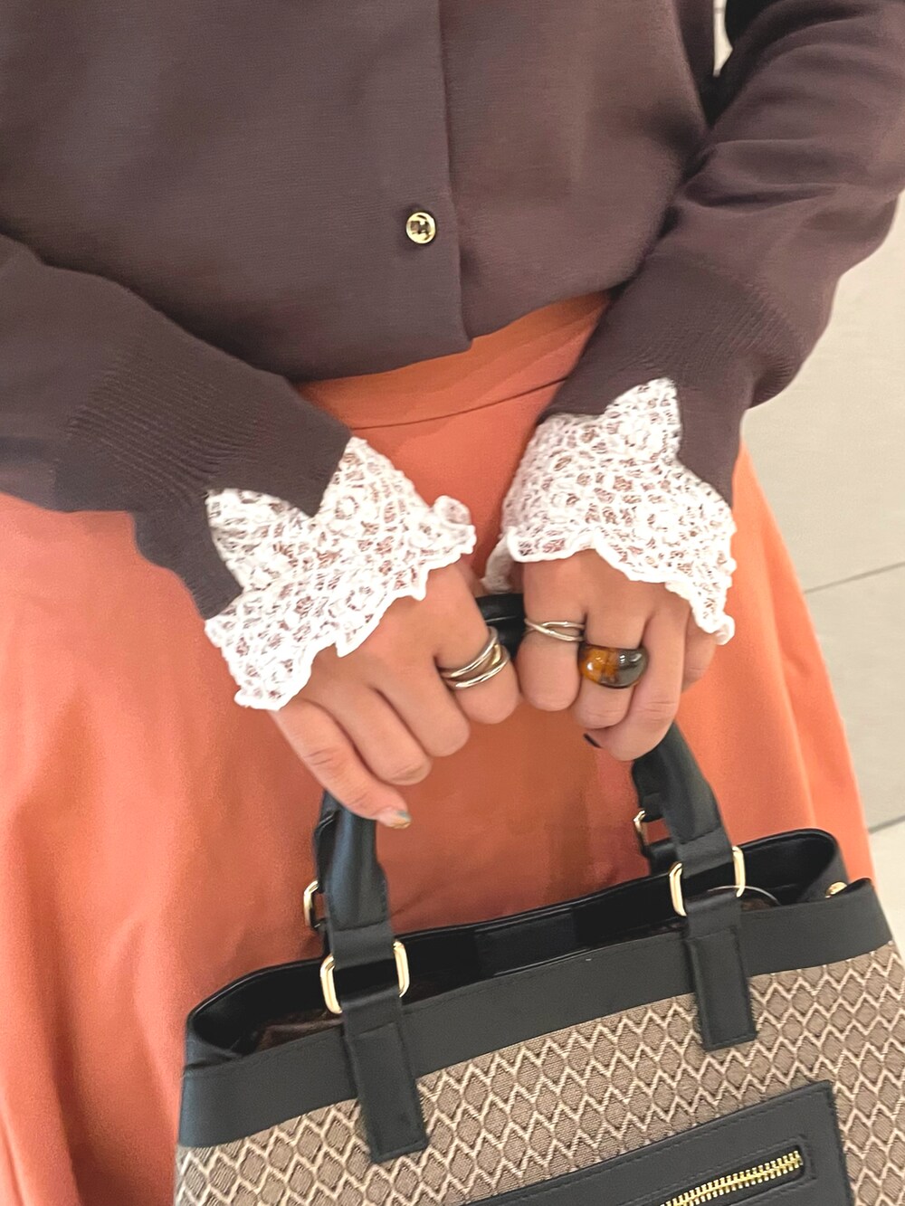 ブラウン系のカーディガン/ボレロ、ホワイト系のTシャツ/カットソー、ブラウン系のハンドバッグを着用したレディースの秋コーディネートの4枚目の写真