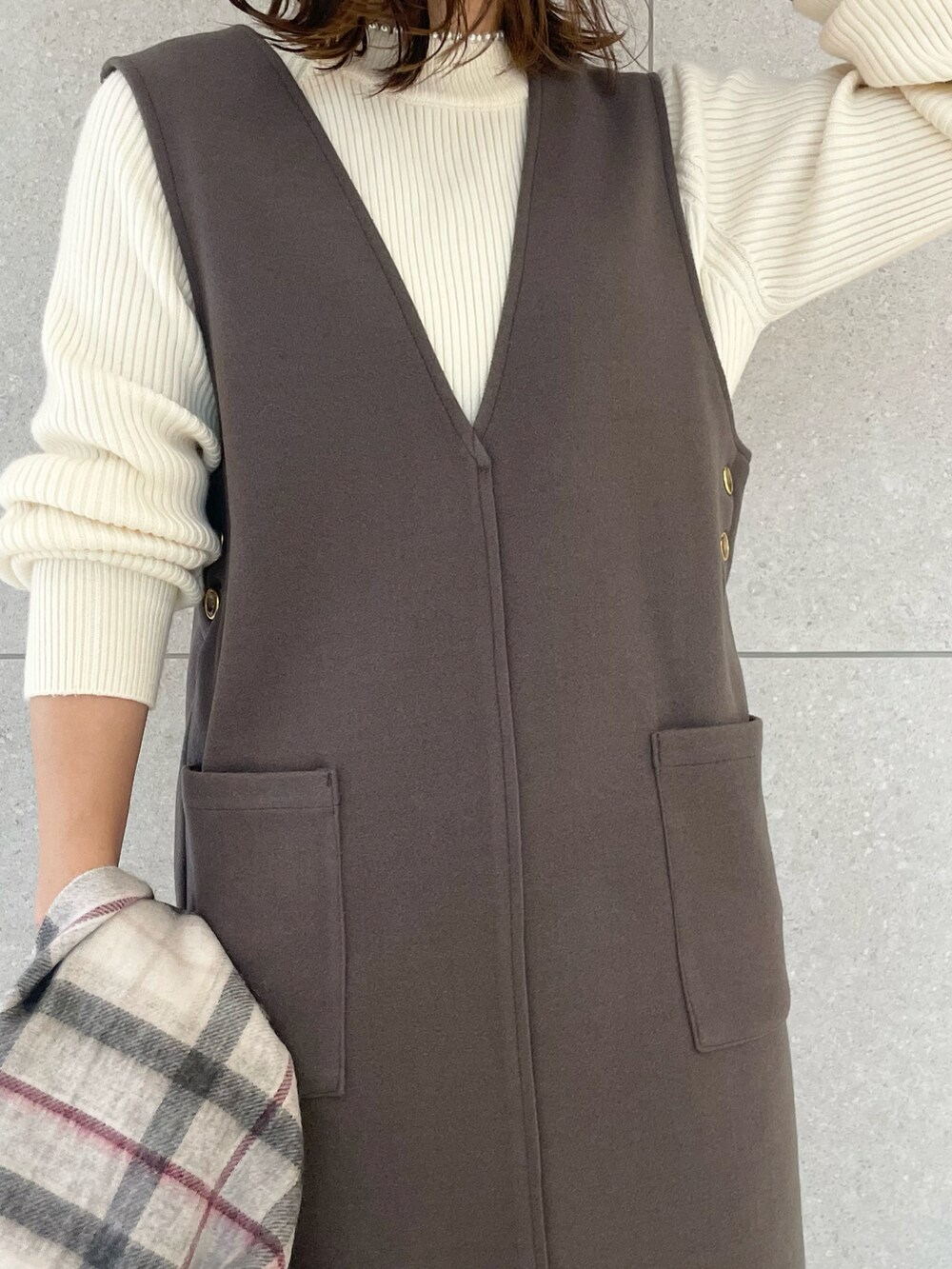 ホワイト系のニット/セーター、グレー系のジャンパースカート、パープル系のハンドバッグを着用したレディースの冬コーディネートの3枚目の写真