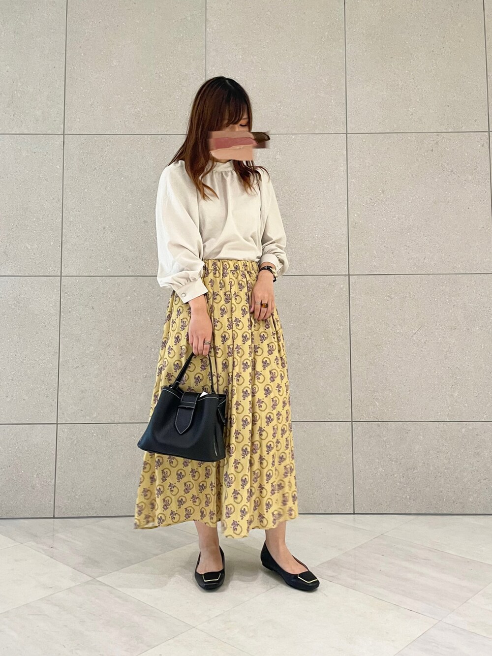 ベージュ系のシャツ/ブラウス、イエロー系のスカート、ブラック系のハンドバッグを着用したレディースの夏コーディネートの2枚目の写真