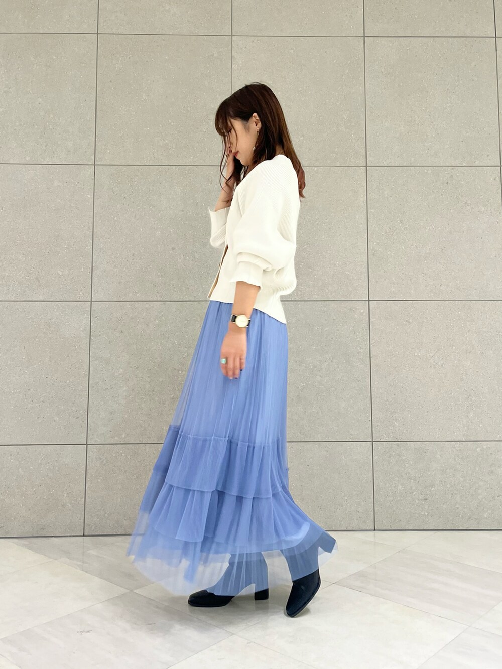 ホワイト系のカーディガン/ボレロ、ブルー系のスカート、ブラック系のブーツを着用したレディースの秋コーディネートの2枚目の写真