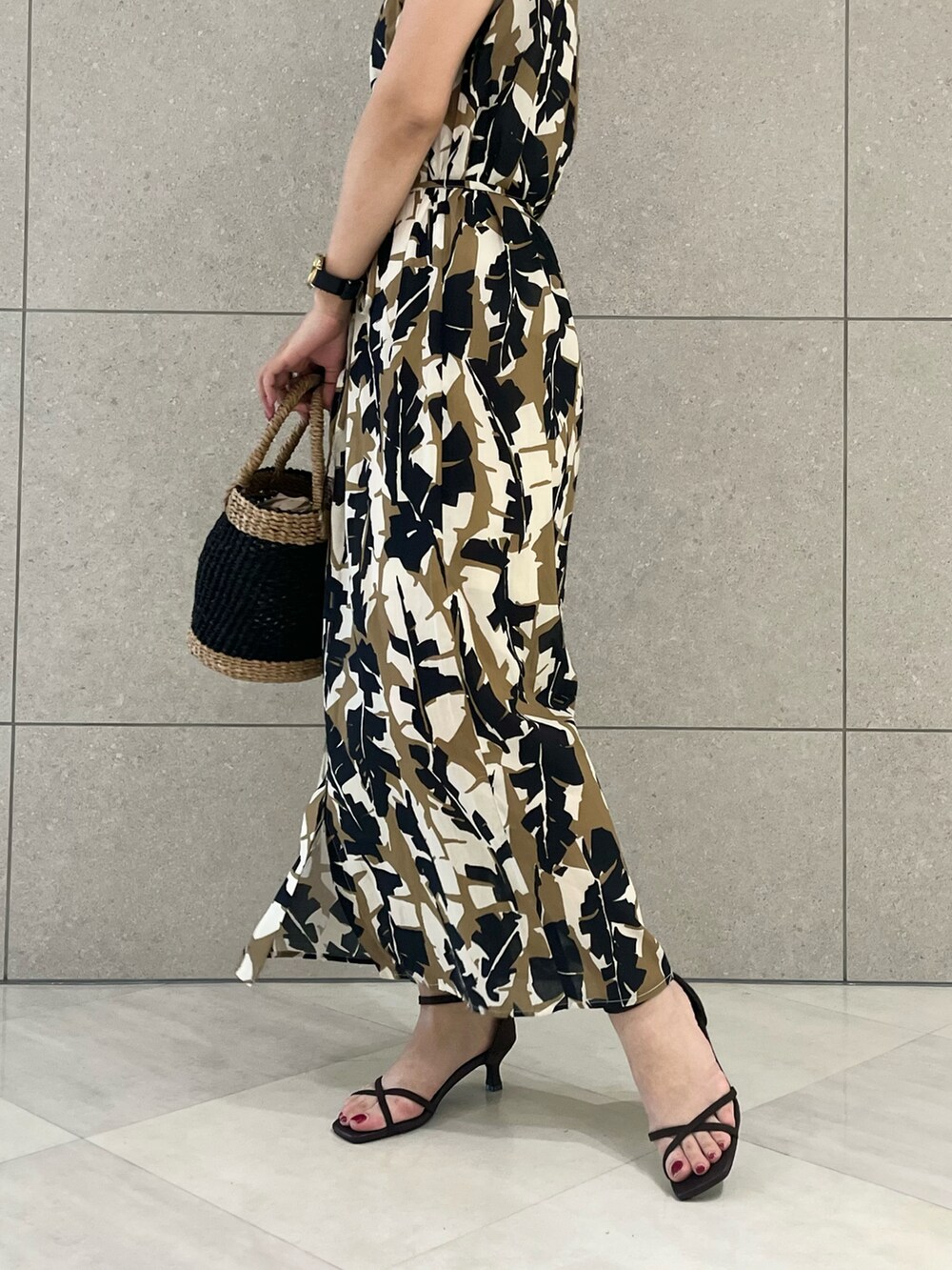 ベージュ系のワンピース、ブラック系のバッグ、ブラウン系のサンダルを着用したレディースの春コーディネートの4枚目の写真