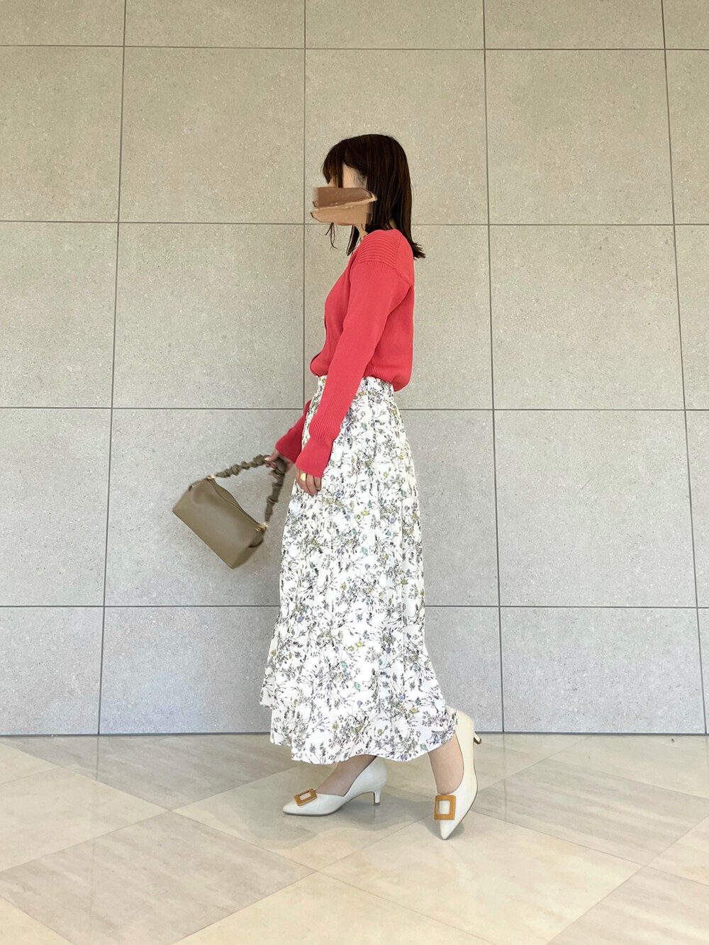 ピンク系のカーディガン/ボレロ、ブラウン系のハンドバッグ、ホワイト系のスカートを着用したレディースの春コーディネートの2枚目の写真