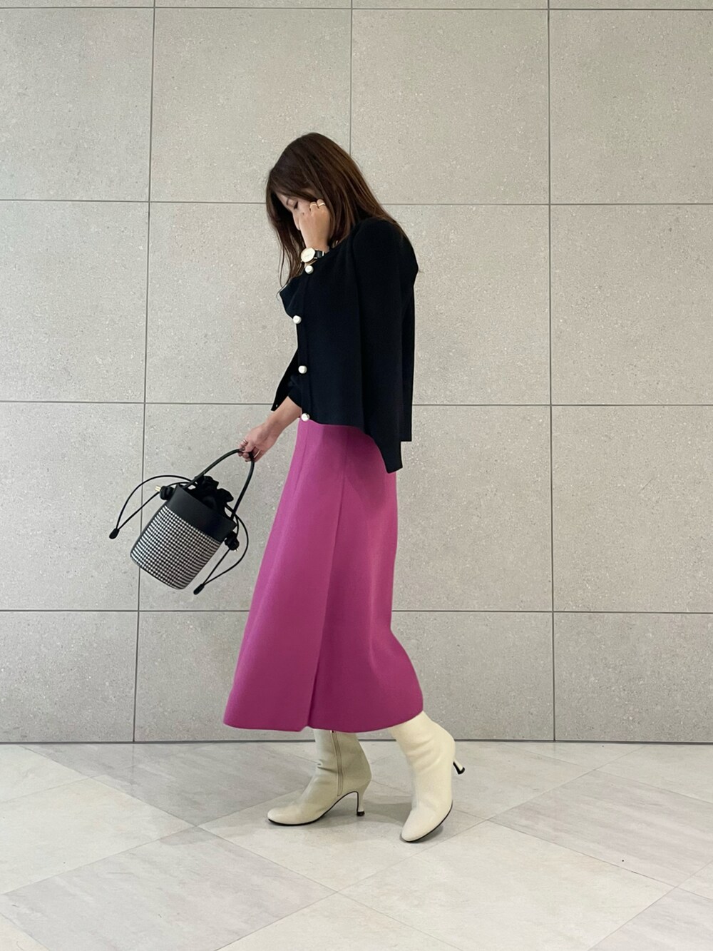 ブラック系のニット/セーター、ブラック系のカーディガン/ボレロ、ピンク系のスカートを着用したレディースの秋コーディネートの2枚目の写真