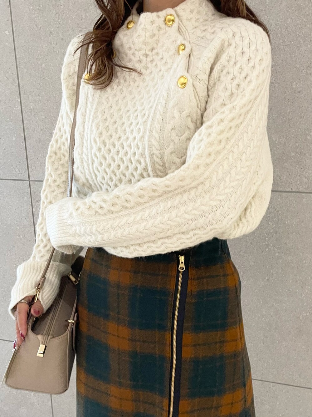 ブラウン系のブーツ、ホワイト系のニット/セーター、オレンジ系のスカートを着用したレディースの秋コーディネートの4枚目の写真